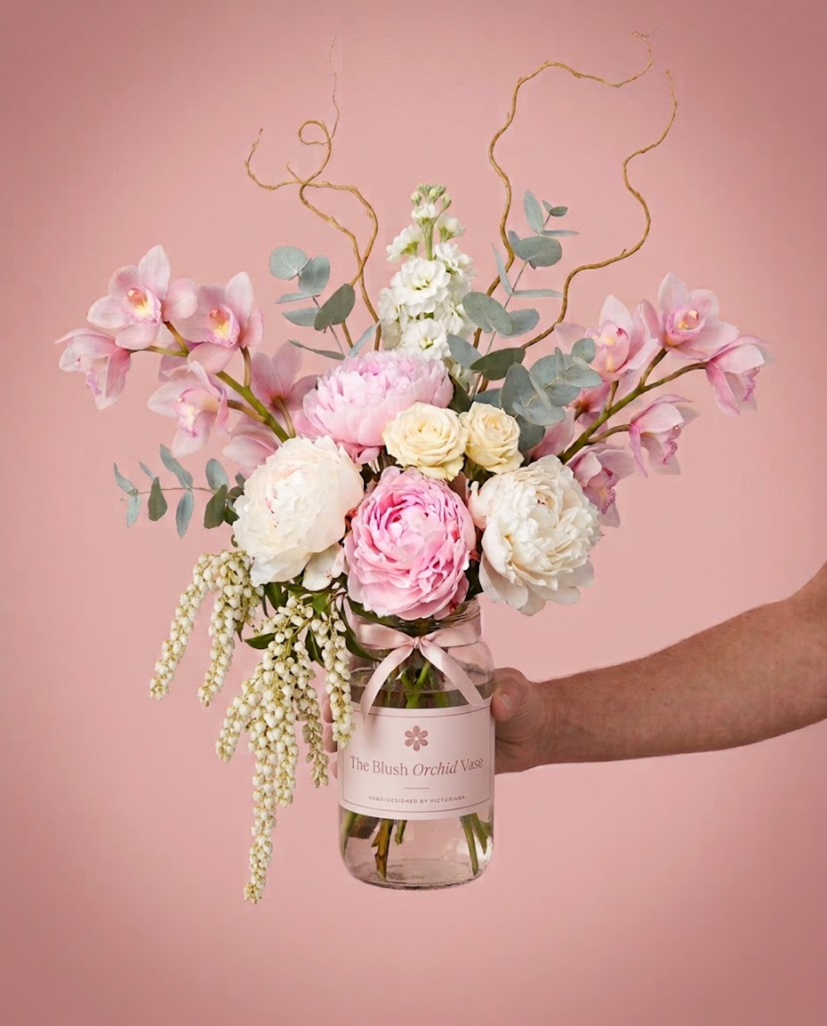 The Blush Orchid Vase flower arrangement in a glass jar with blush label by Victoriana Florist